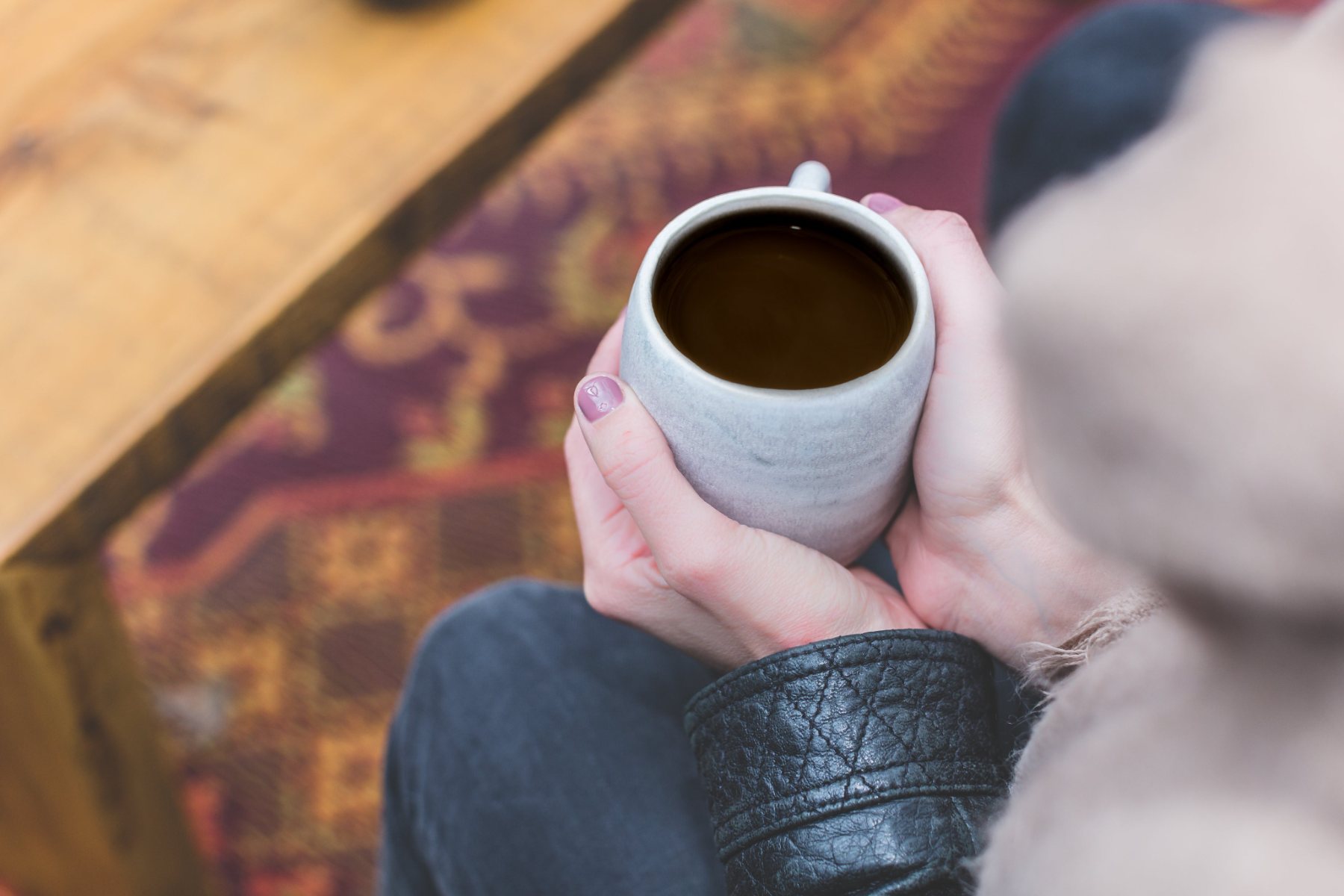 Hands cradling a warm cup of coffee